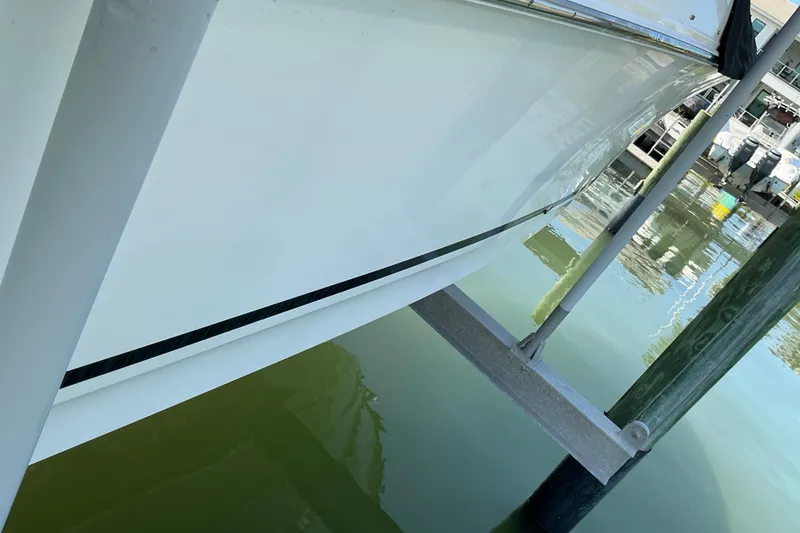Slide: The Image of 2017 Boston Whaler 250 Outrage boat hull on a lift, dockside view. - 48
