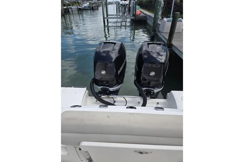 Slide: The Image of Twin Mercury outboard engines on a 2017 Boston Whaler 250 Outrage boat at a dock. - 5