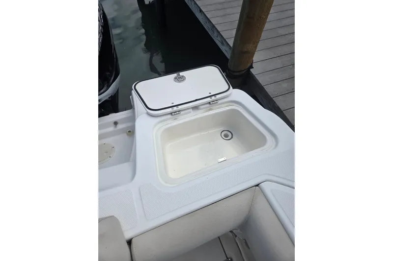 Slide: The Image of Boston Whaler 250 Outrage 2017 boat with open storage compartment at dock. - 6