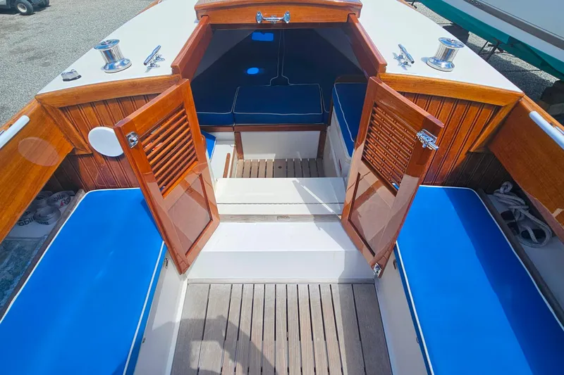 Slide: The Image of Interior view of 2003 Herreshoff Alerion 26 sailboat with wooden doors and blue cushions. - 14
