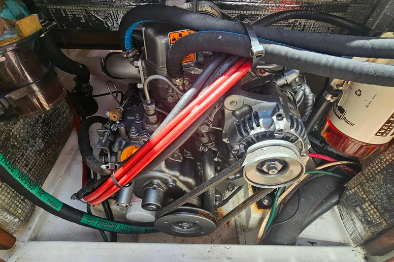 Slide: The Image of Engine compartment of a 2003 Herreshoff Alerion 26 sailboat, featuring hoses and alternator. - 17