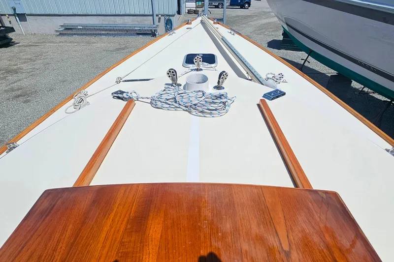 Slide: The Image of Deck view of 2003 Herreshoff Alerion 26 sailboat with wooden accents and coiled ropes. - 8