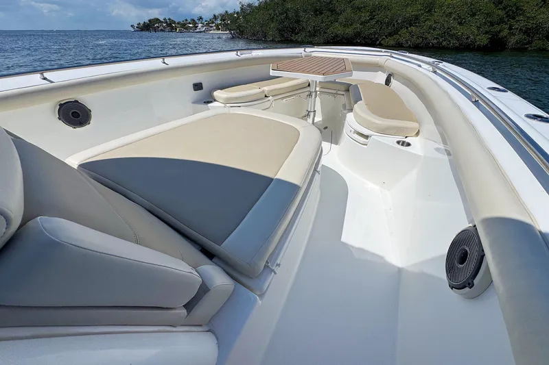 Slide: The Image of 2019 Boston Whaler 350 Outrage boat interior with cushioned seating and ocean view. - 12