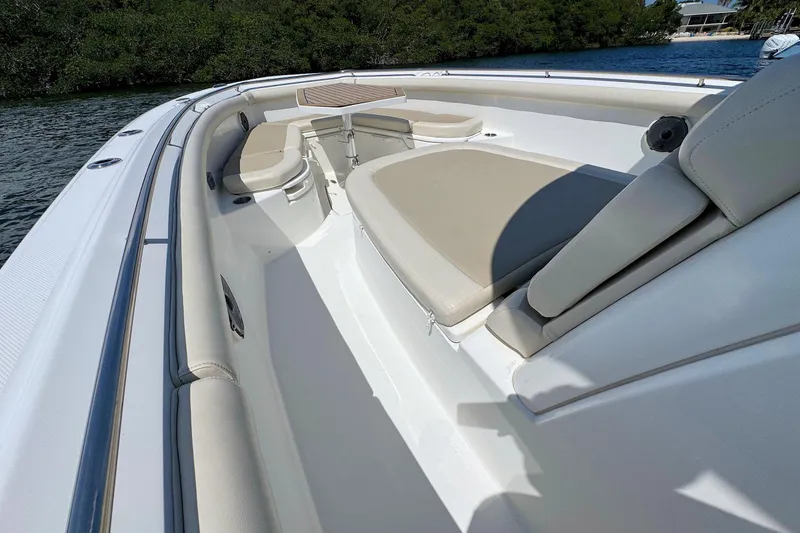 Slide: The Image of 2019 Boston Whaler 350 Outrage boat interior with cushioned seating and sleek design. - 13