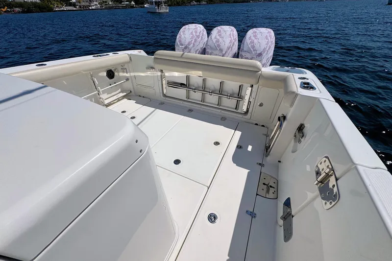 Slide: The Image of 2019 Boston Whaler 350 Outrage boat deck with seating and rod holders on the water. - 6