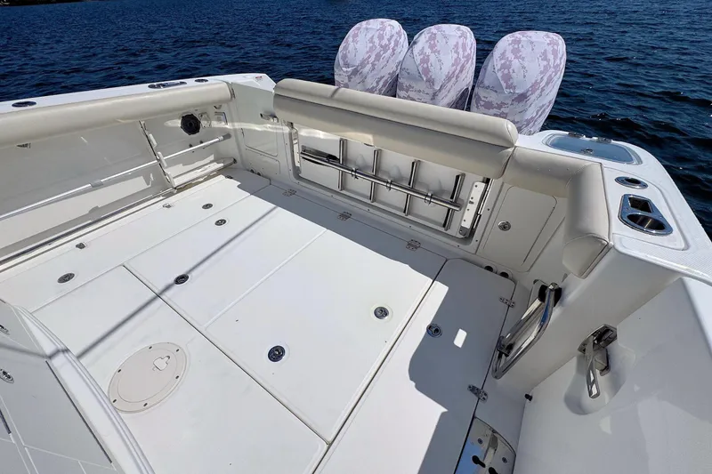 Slide: The Image of 2019 Boston Whaler 350 Outrage boat deck with seating and triple engines on water. - 7