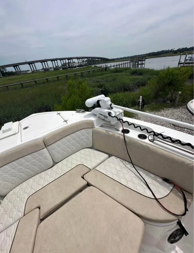 Slide: The Image of 2021 Sea Fox 268 Commander boat interior with cushioned seating, near a scenic bridge view. - 5