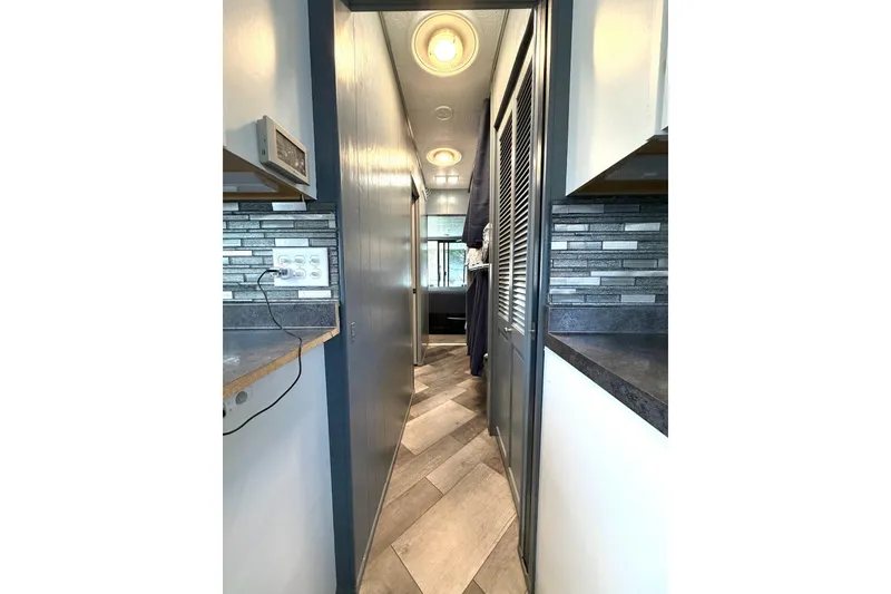 Slide: The Image of Narrow hallway in a 1989 Sumerset 14x62 houseboat with modern decor and lighting. - 13