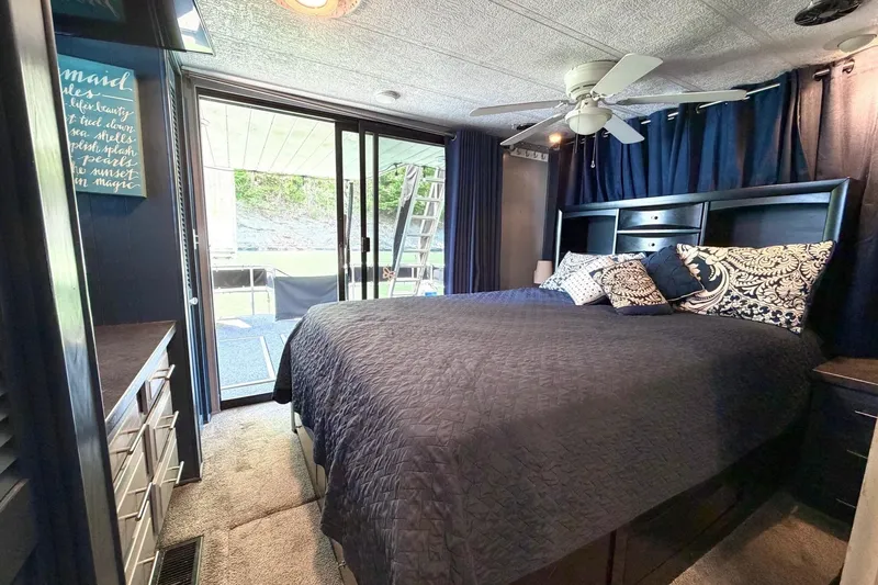 Slide: The Image of Cozy bedroom in a 1989 Sumerset 14x62 houseboat with elegant decor and outdoor view. - 18