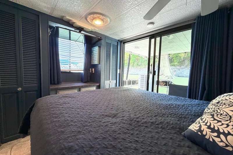 Slide: The Image of Cozy bedroom in 1989 Sumerset 14x62 houseboat with outdoor view through sliding glass doors. - 19