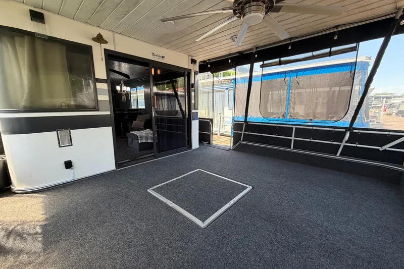 Slide: The Image of 1989 Sumerset 14x62 houseboat interior with carpeted deck and ceiling fan. - 2