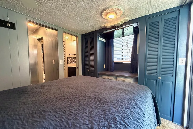 Slide: The Image of Cozy bedroom in a 1989 Sumerset 14x62 houseboat with blue accents and natural light. - 20