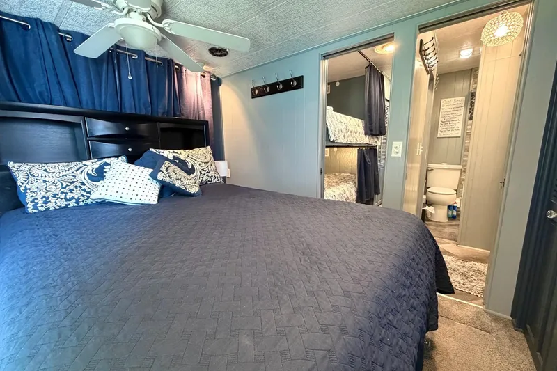 Slide: The Image of Cozy bedroom in 1989 Sumerset 14x62 houseboat with blue decor and adjacent bathroom. - 21