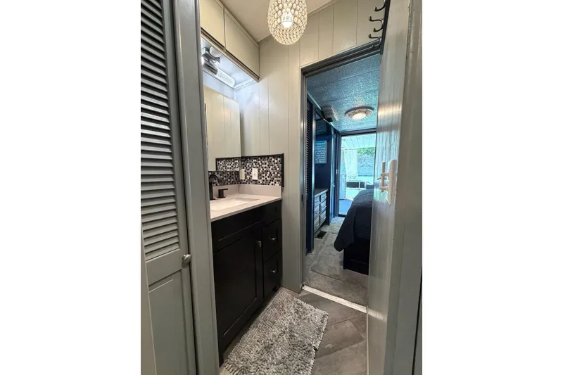 Slide: The Image of 1989 Sumerset 14x62 houseboat interior with modern bathroom and cozy bedroom view. - 22