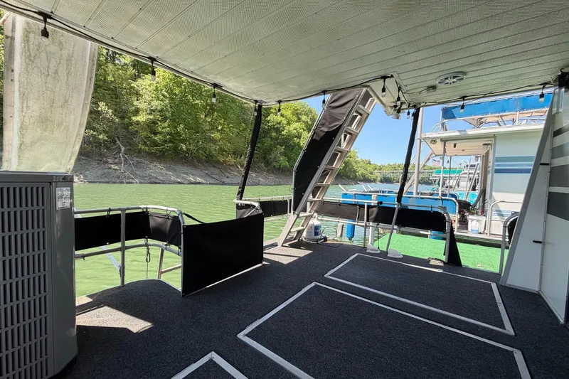 Slide: The Image of 1989 Sumerset 14x62 houseboat interior with lake view and outdoor seating area. - 26
