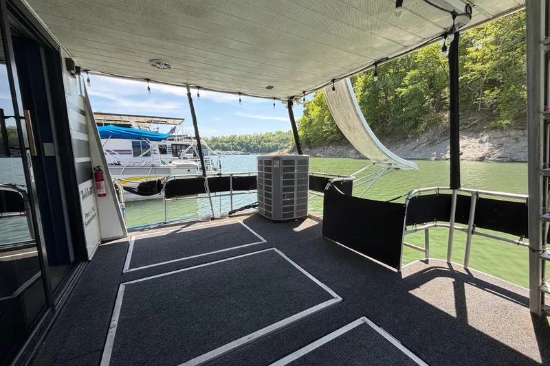 Slide: The Image of 1989 Sumerset 14x62 houseboat deck with scenic lake view and neighboring boats. - 27