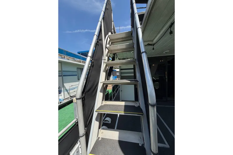 Slide: The Image of Staircase on 1989 Sumerset 14x62 houseboat under clear blue sky. - 29