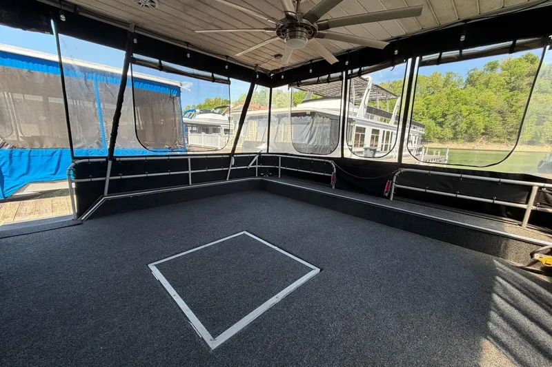 Slide: The Image of 1989 Sumerset 14x62 houseboat interior with carpeted deck and ceiling fan. - 3