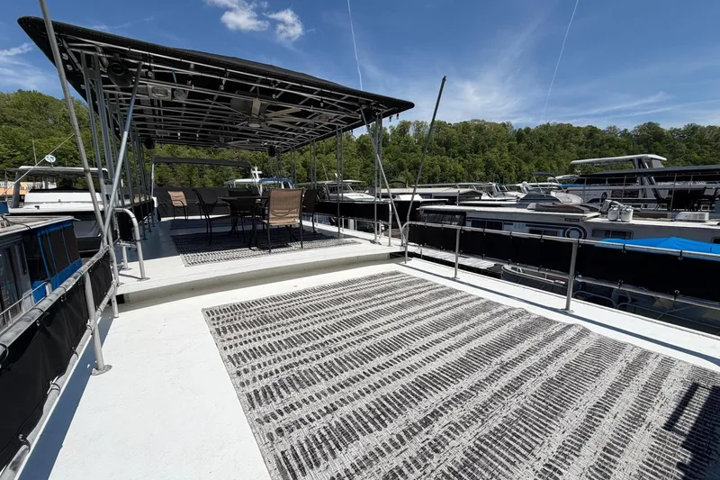 Slide: The Image of 1989 Sumerset 14x62 houseboat with spacious deck, outdoor seating, and canopy under clear skies. - 30