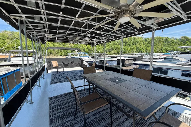 Slide: The Image of Outdoor deck of a 1989 Sumerset 14x62 houseboat with dining table and ceiling fan. - 34