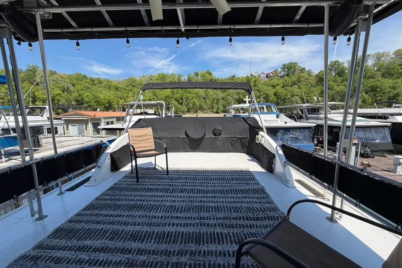 Slide: The Image of Rooftop deck of a 1989 Sumerset 14x62 houseboat, featuring outdoor seating and scenic marina views. - 36