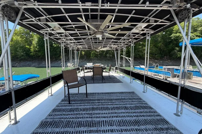 Slide: The Image of 1989 Sumerset 14x62 houseboat deck with chairs, ceiling fan, and scenic lake view. - 37