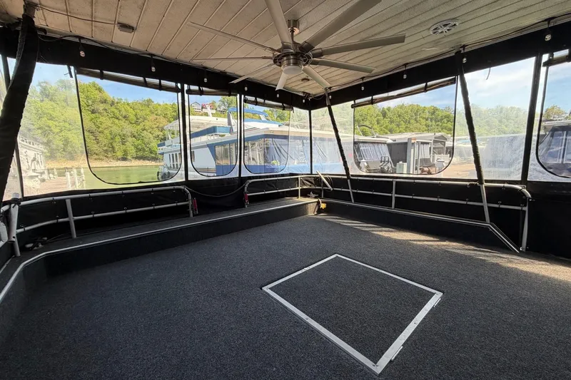 Slide: The Image of 1989 Sumerset 14x62 houseboat interior with carpeted deck and ceiling fan. - 4