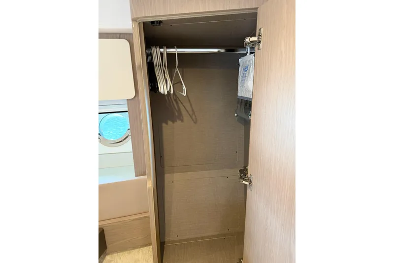 Slide: The Image of 2024 Azimut Fly 50 yacht interior closet with hangers and porthole view. - 28