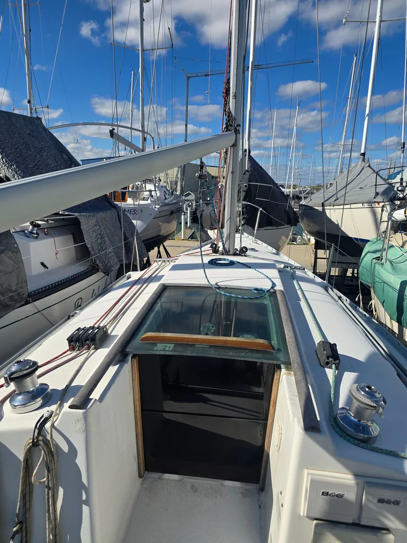 Slide: The Image of 1994 Beneteau First 265 sailboat docked under blue sky. - 8