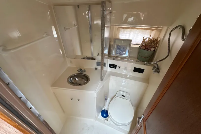Slide: The Image of 1998 Carver 355 Aft Cabin Motor Yacht bathroom with sink, toilet, and shower. - 11