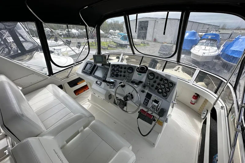 Slide: The Image of 1998 Carver 355 Aft Cabin Motor Yacht helm with navigation instruments and seating. - 5
