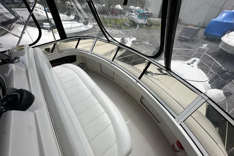 Slide: The Image of 1998 Carver 355 Aft Cabin Motor Yacht interior with white seating and panoramic windows. - 6