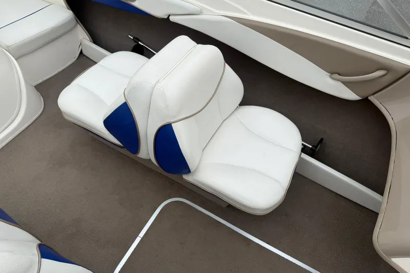 Slide: The Image of Interior seating of a 2003 Bayliner 185 boat with white and blue upholstery. - 10