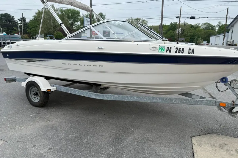 Slide: The Image of 2003 Bayliner 185 boat on trailer, parked outdoors, with registration number visible. - 6