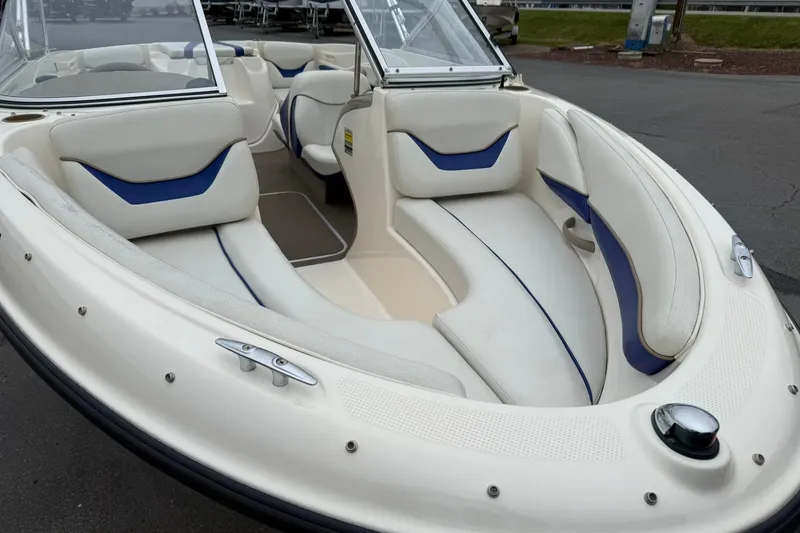 Slide: The Image of 2003 Bayliner 185 boat interior with white and blue seating, showcasing spacious design. - 7