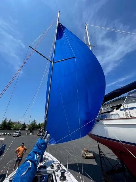 Slide: The Image of Beneteau First 24 sailboat with blue sail, 2021 model, docked. - 2