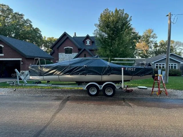 Slide: The Image of 2021 Beneteau First 24 sailboat on trailer, covered, parked in residential area. - 5