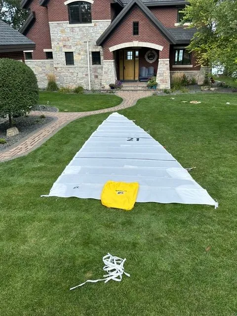Slide: The Image of Beneteau First 24 sail on lawn in front of brick house, 2021 model. - 8