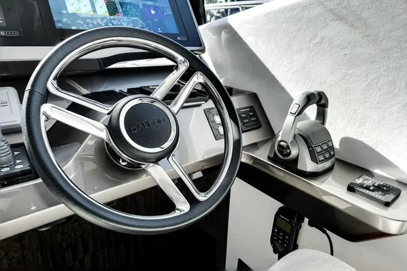 Slide: The Image of 2024 Galeon 500 Fly yacht helm with steering wheel and control panel. - 48