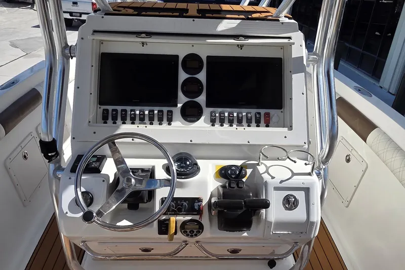 Slide: The Image of 2008 Key West 293 Center Console boat dashboard with steering wheel and controls. - 11