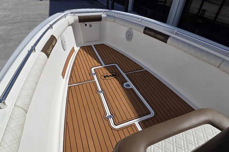 Slide: The Image of 2008 Key West 293 Center Console boat interior with teak flooring and cushioned seating. - 5