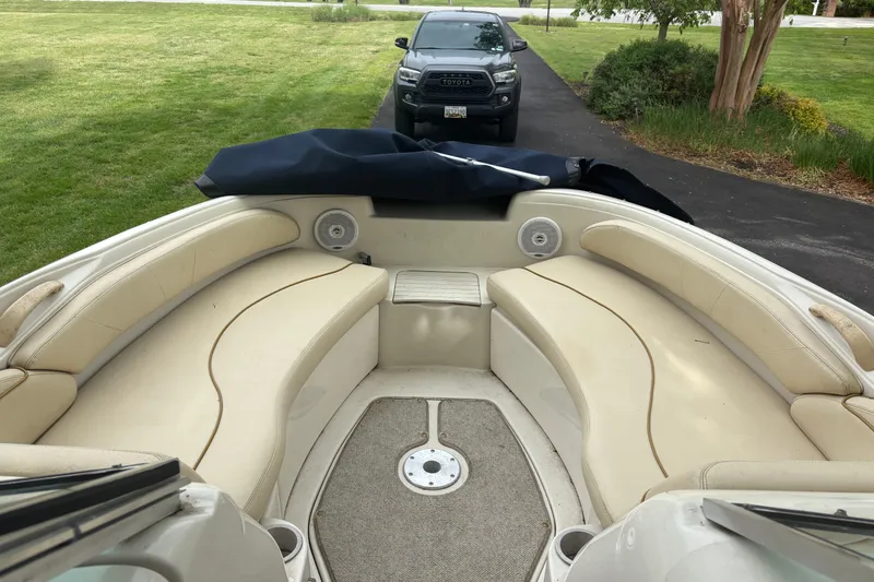 Slide: The Image of 2001 Sea Ray 210 Sundeck boat interior with beige seating and outdoor setting. - 3