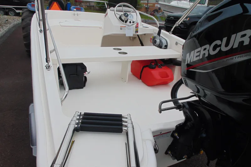 Slide: The Image of 2026 Boston Whaler 130 Super Sport boat interior with Mercury engine and red fuel tank. - 10