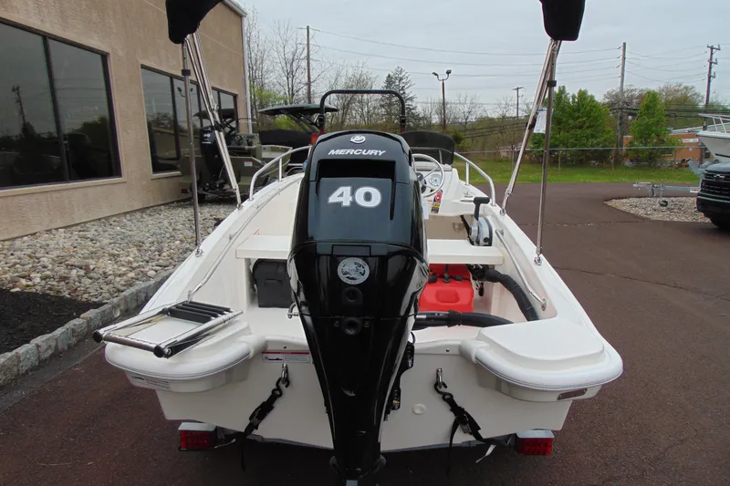Slide: The Image of 2026 Boston Whaler 130 Super Sport with Mercury engine, parked outdoors. - 4