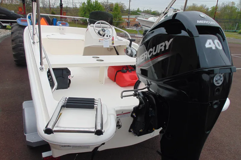 Slide: The Image of 2026 Boston Whaler 130 Super Sport boat with Mercury 40 engine, parked outdoors. - 5