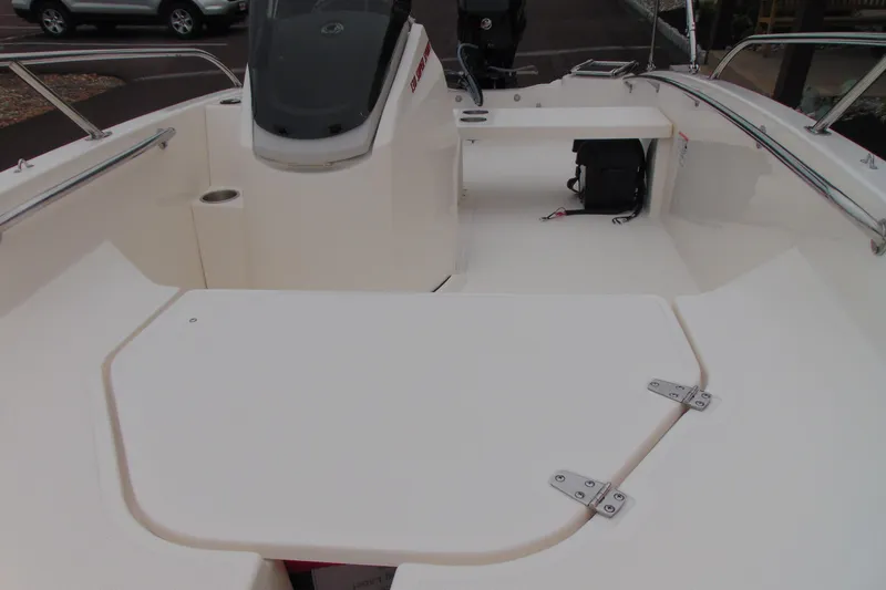 Slide: The Image of 2026 Boston Whaler 130 Super Sport boat interior with seating and storage compartments. - 9