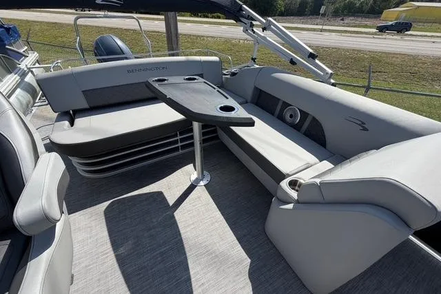 Slide: The Image of 2021 Bennington L22 boat interior with gray seating and a central table. - 11