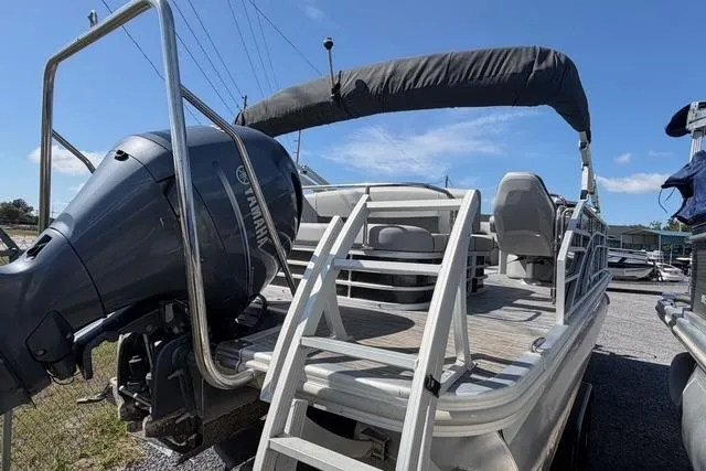 Slide: The Image of 2021 Bennington L22 pontoon boat with Yamaha outboard motor and ladder, docked outdoors. - 5