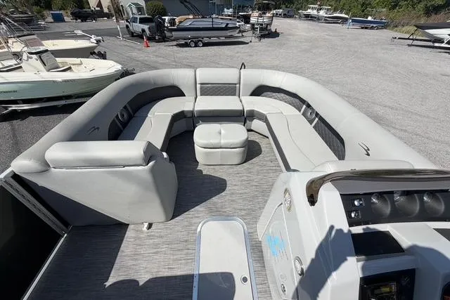 Slide: The Image of 2021 Bennington L22 pontoon boat with spacious seating and modern design in a marina setting. - 9