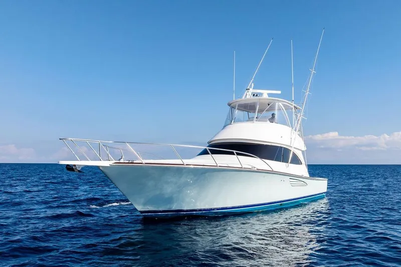 Slide: The Image of 2022 Viking 48 Convertible yacht cruising on open sea under clear blue sky. - 10